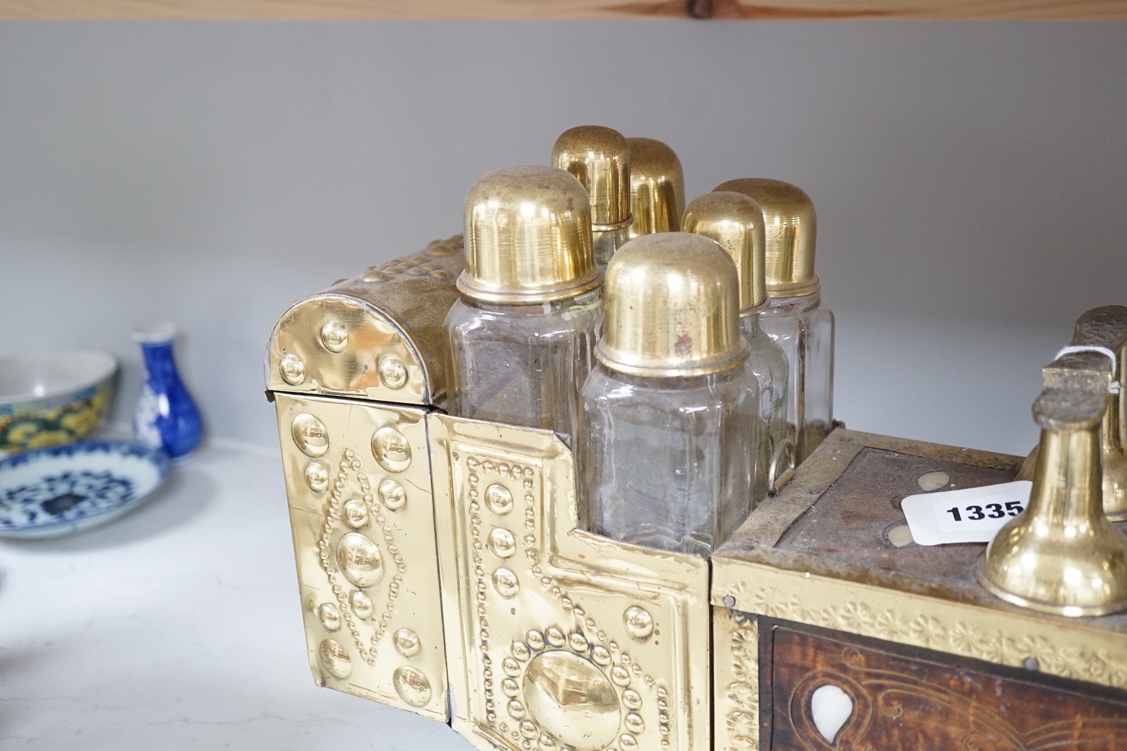 An Indian brass & hardwood shoe shiner's set, with twelve flasks. 57cm. long. 15cm. deep. 28cm. high